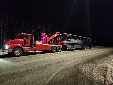 towing a coach bus with the words Alaska Explorer on the side