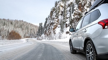 SUV driving on road in winter with tires shown